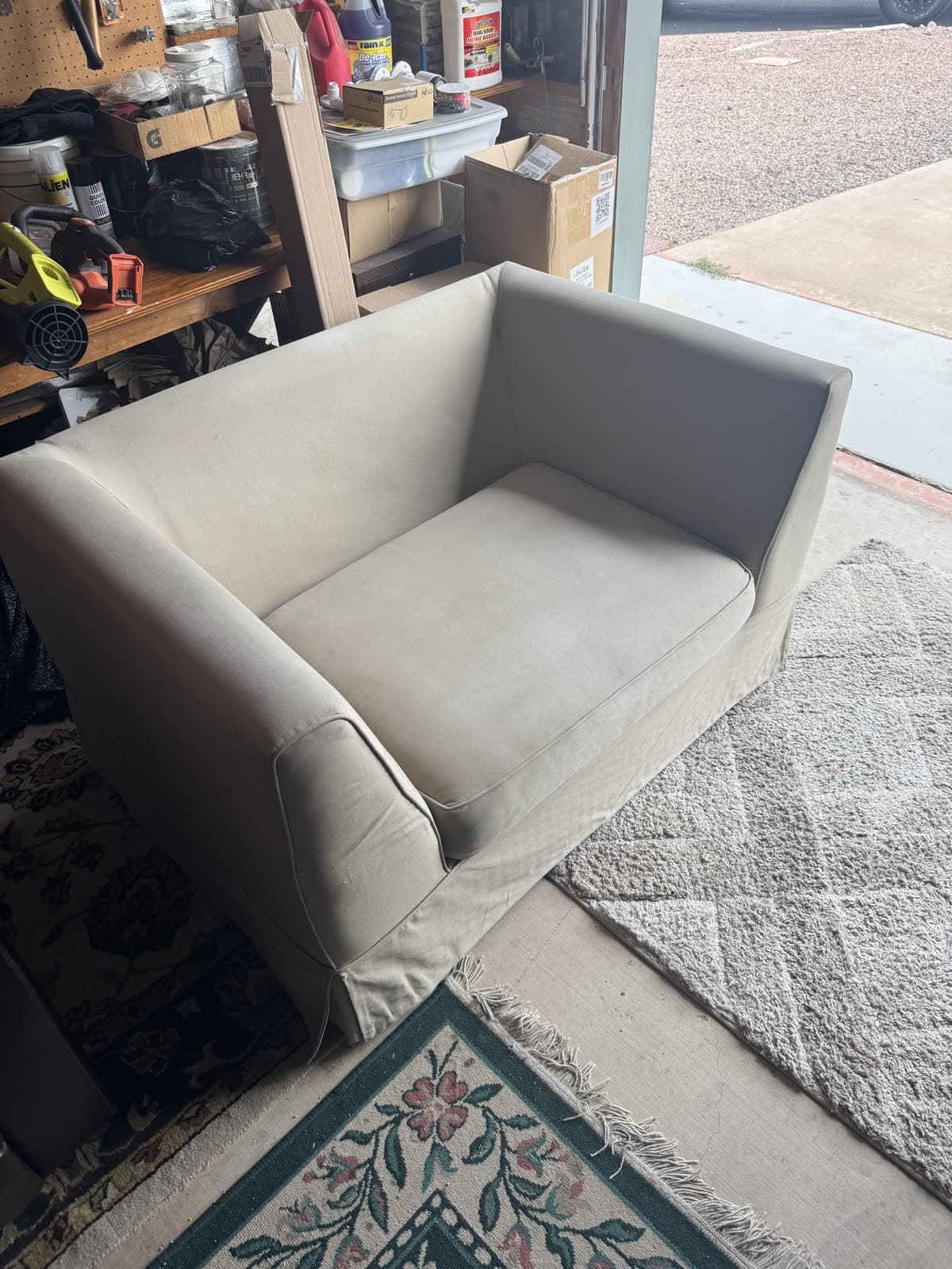 Beige armchair in a garage before being carried out for junk removal