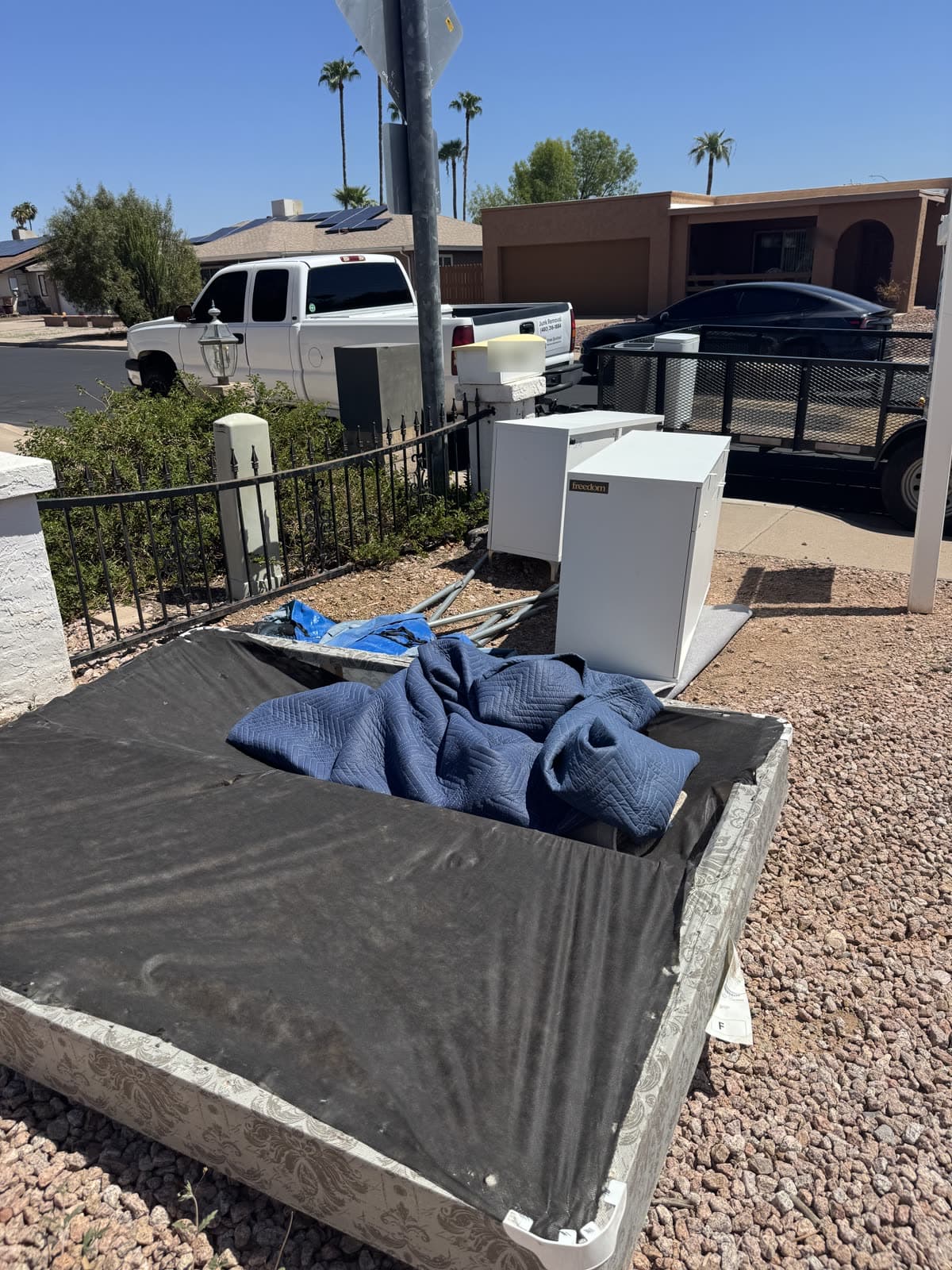 Curbside furniture pile with the Sonoran Standard truck and trailer parked at the street