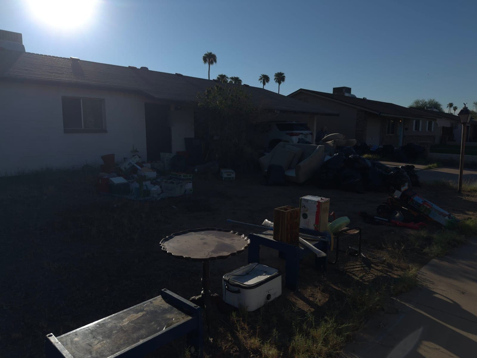 Front yard covered with furniture, boxes and bags early in the morning