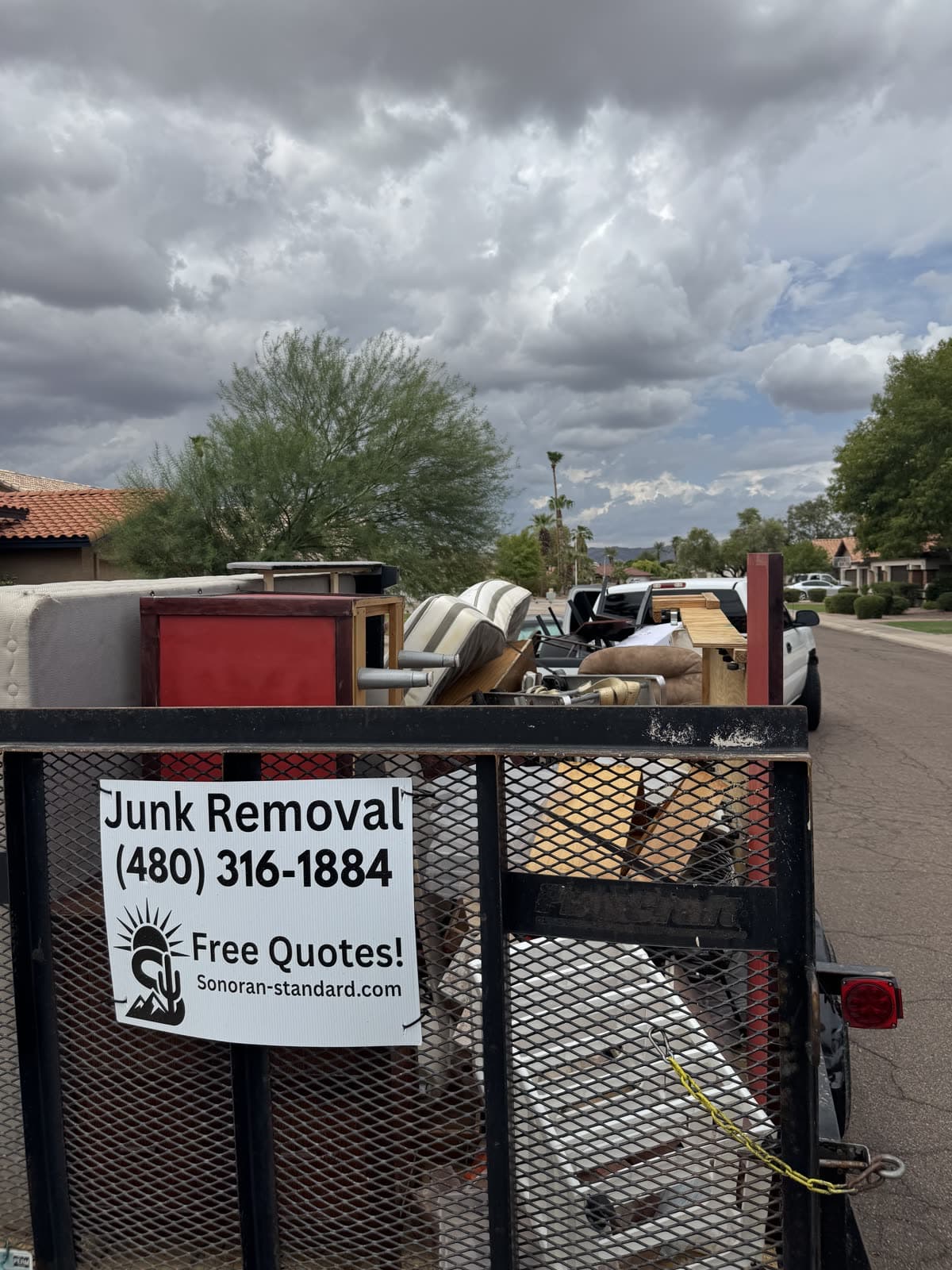 Sonoran Standard trailer loaded with furniture and bins under dark monsoon clouds